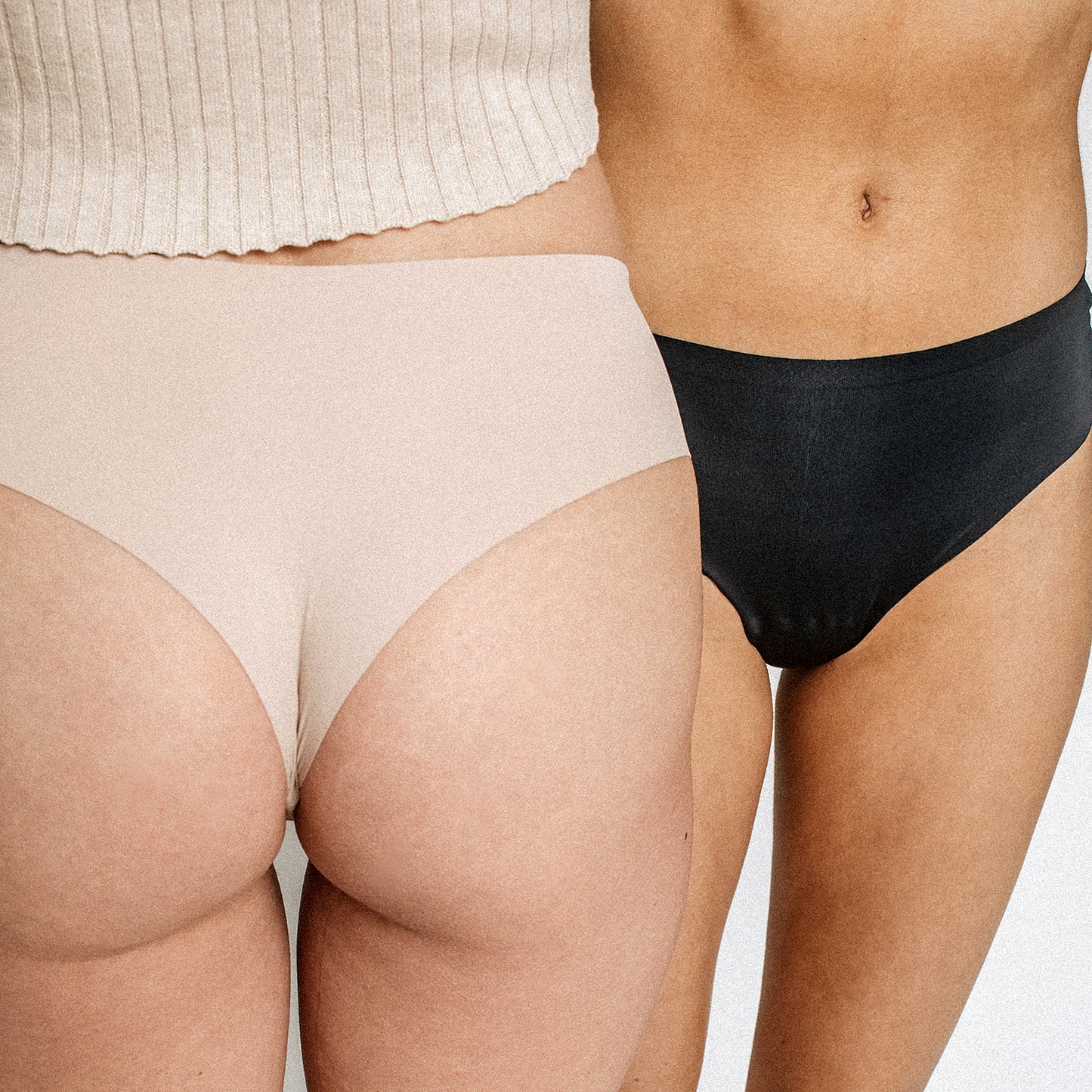 Two women wearing Simply Clad camel toe proof thong underwear in beige and black — seamless fit, no panty lines, wide back design for no digging or wedgies.