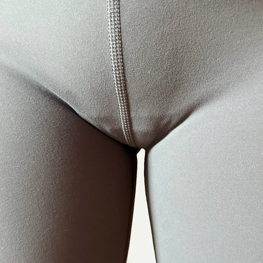 Close-up of gray leggings showing visible outline caused by overpriced camel toe concealing underwear. Expensive options over $35 often fail when wet—revealing camel toe and obvious pad lines despite the premium price.