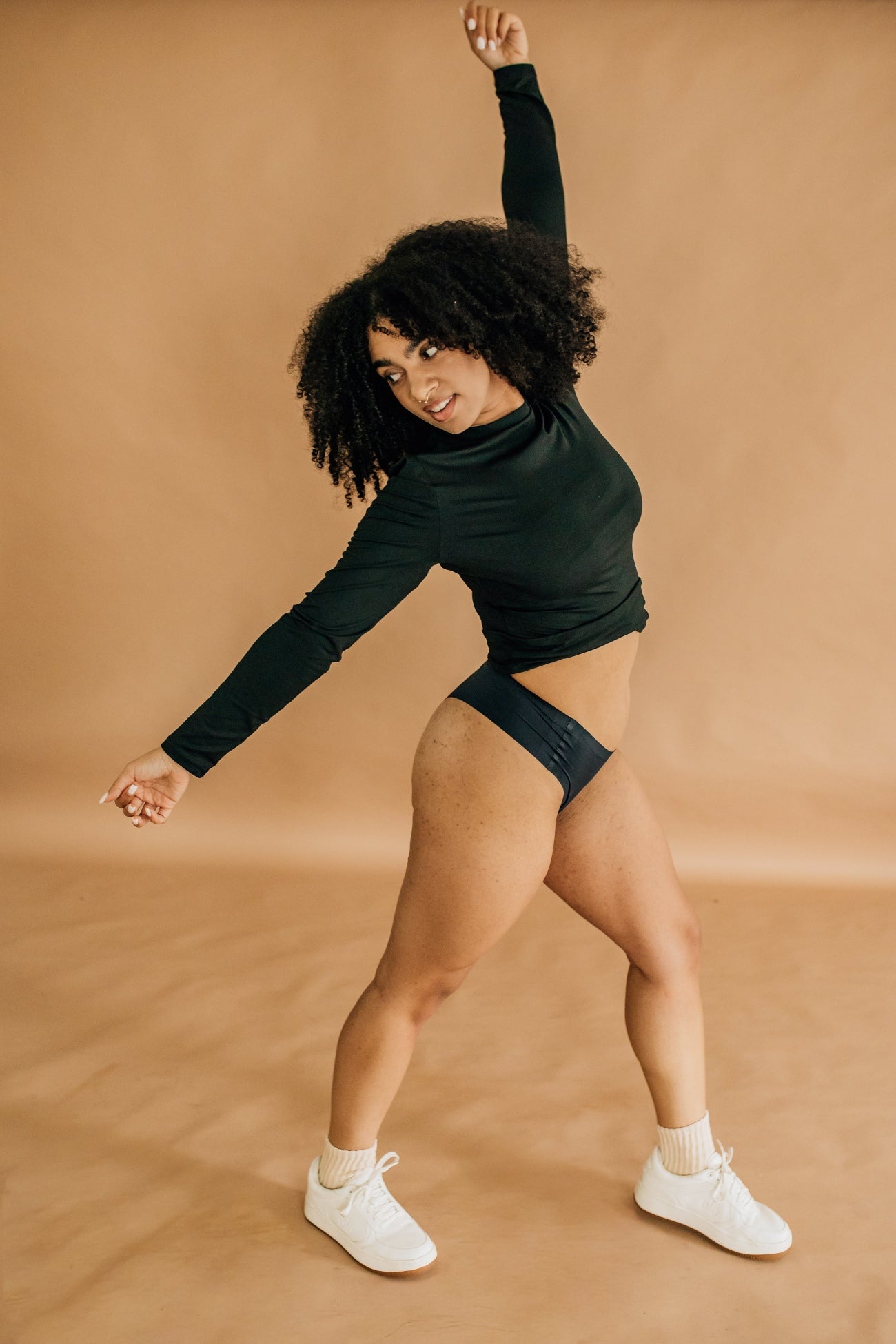 Woman moving confidently in black Simply Clad camel toe proof thong underwear, featuring a seamless no-front-seam design that stays in place during active movement.